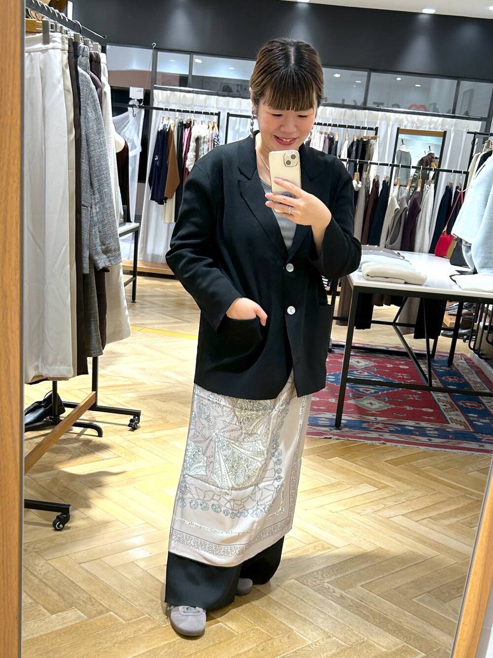 グレー系のスニーカー、ブラック系のパンツドレス、グレー系のTシャツ/カットソーを着用したレディースの秋コーディネートの1枚目の写真