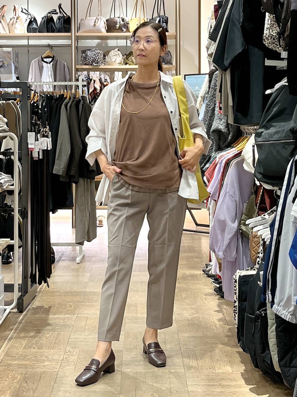 ブラウン系のローファー、イエロー系のトートバッグ、ブラウン系のその他パンツを着用したレディースの秋コーディネートの1枚目の写真