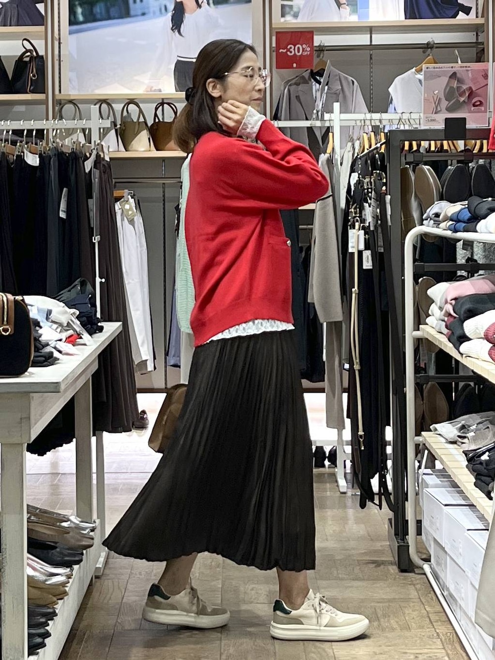 レッド系のカーディガン/ボレロ、ベージュ系のショルダーバッグ、ホワイト系のTシャツ/カットソーを着用したレディースの秋コーディネートの1枚目の写真