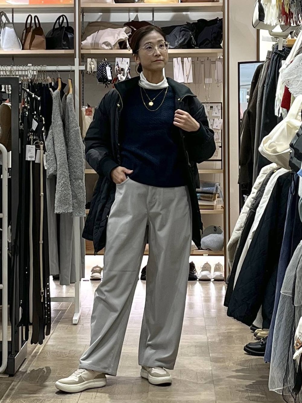 ブラック系のダウンジャケット/コート、ブラック系のボストンバッグ、グレー系のその他パンツを着用したレディースの秋コーディネートの1枚目の写真