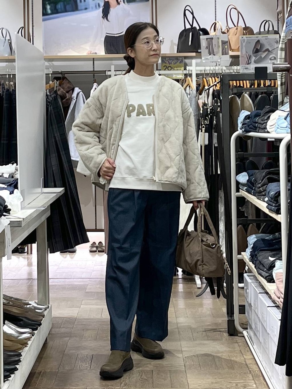 ベージュ系のトートバッグ、ベージュ系のブルゾン、ホワイト系のニット/セーターを着用したレディースの秋コーディネートの1枚目の写真