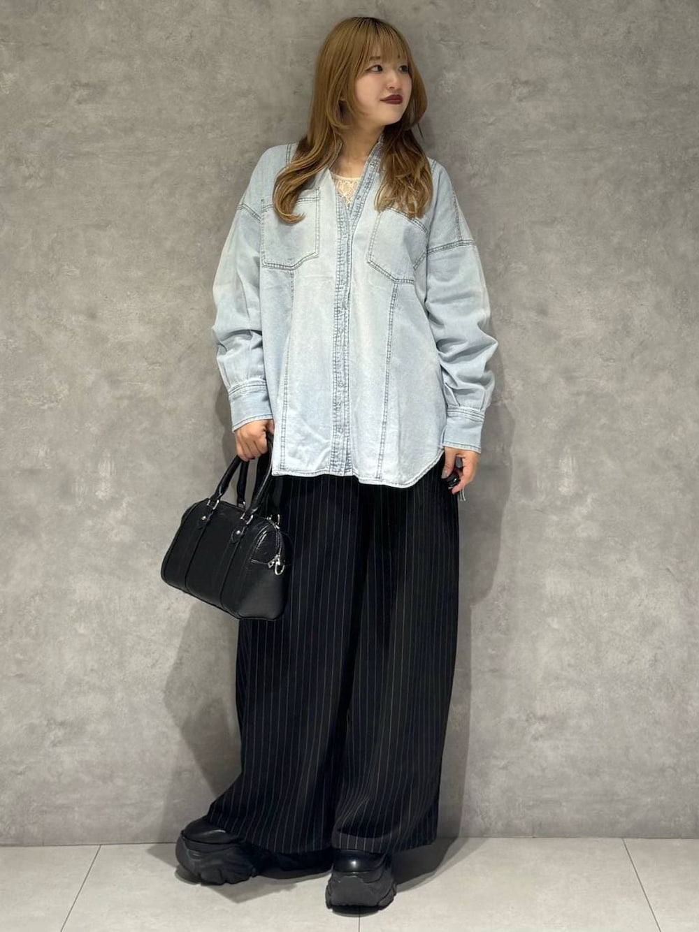 ブラック系のブーツ、ホワイト系のTシャツ/カットソー、ブラック系のボストンバッグを着用したレディースの冬コーディネートの1枚目の写真