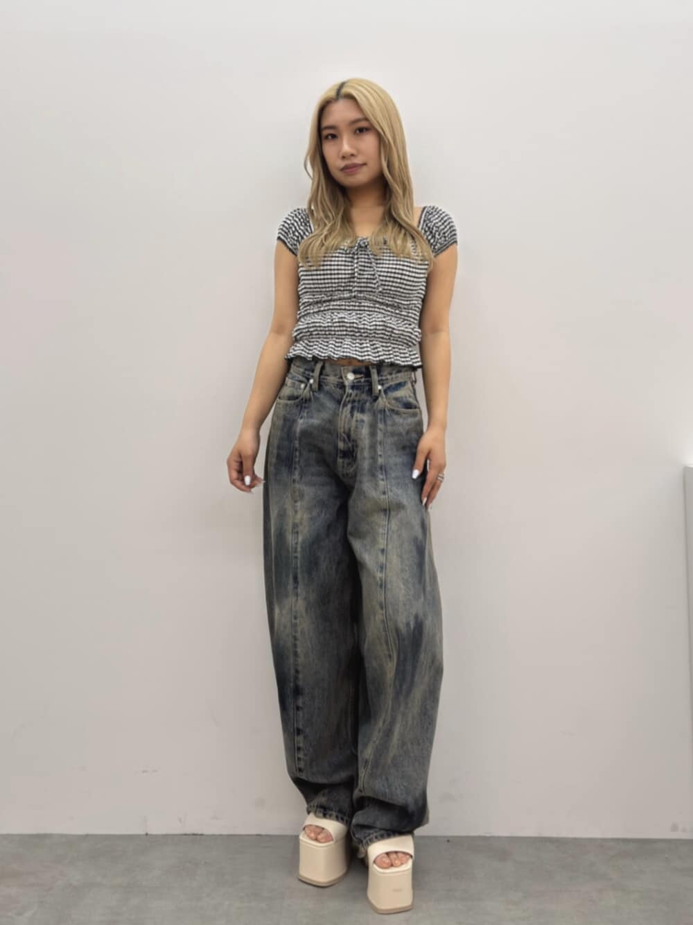 ブルー系のデニムパンツ、ホワイト系のサンダル、その他のTシャツ/カットソーを着用したレディースの春コーディネートの1枚目の写真