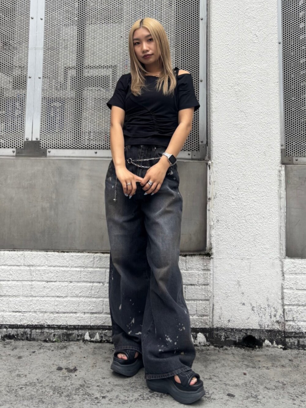 ブラック系のサンダル、ブラック系のTシャツ/カットソー、ブラック系のデニムパンツを着用したレディースの春コーディネートの1枚目の写真