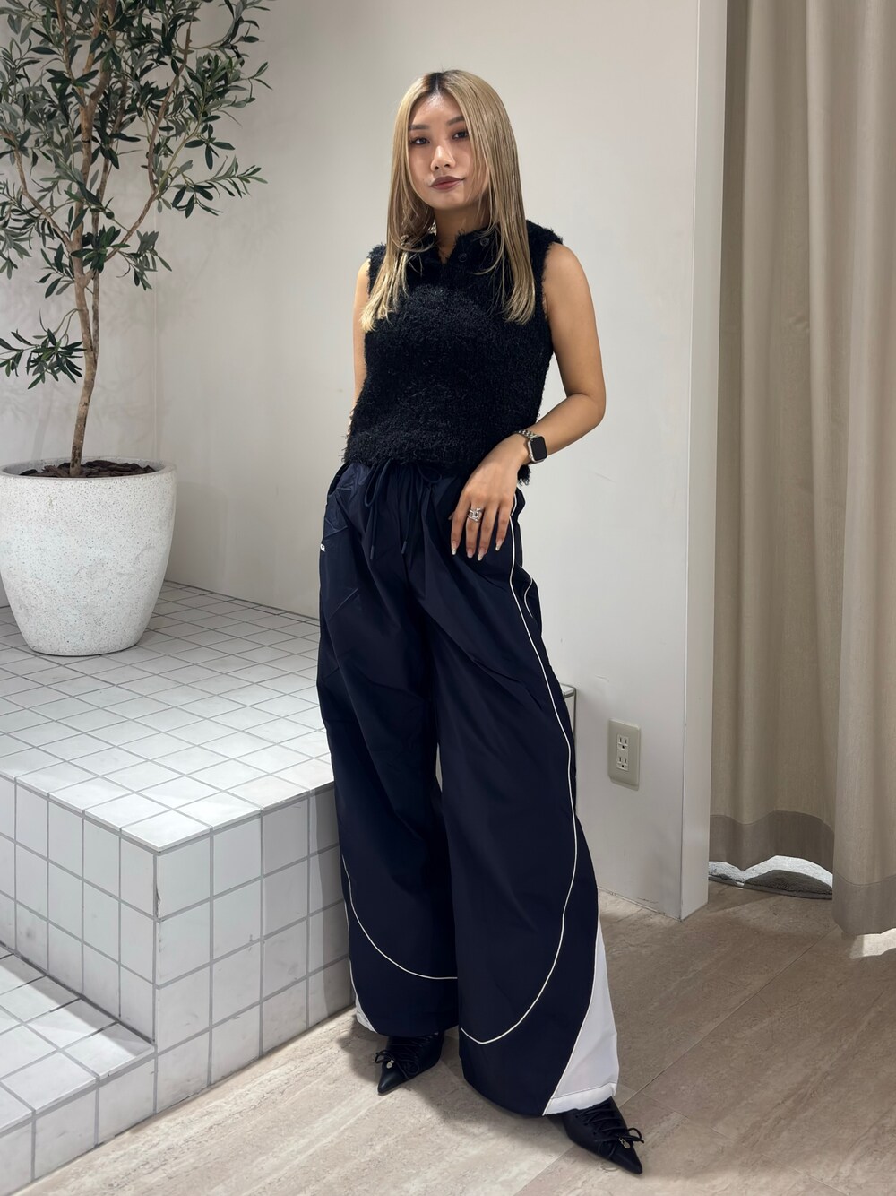 ブラック系のニット/セーター、ブルー系のその他パンツ、ブラック系のパンプスを着用したレディースの春コーディネートの1枚目の写真