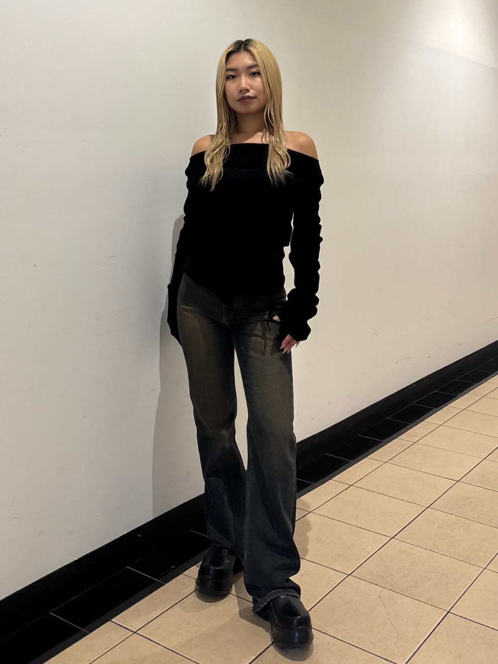 ブルー系のデニムパンツ、ブラック系のスリッポン、ブラック系のTシャツ/カットソーを着用したレディースの秋コーディネートの1枚目の写真