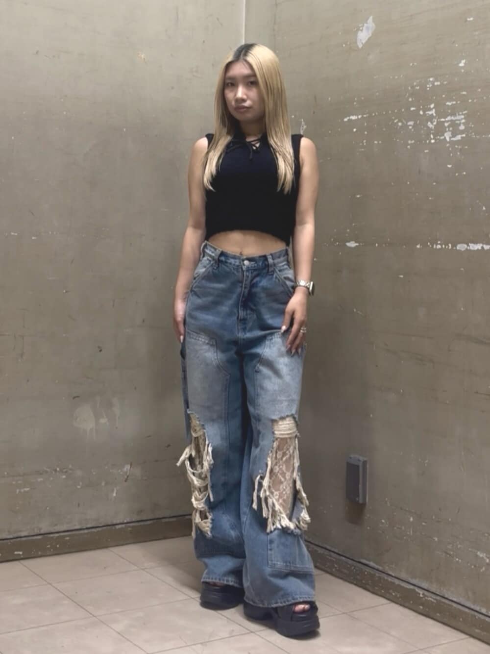 ブルー系のデニムパンツ、ブラック系のニット/セーター、ブラック系のサンダルを着用したレディースの夏コーディネートの1枚目の写真