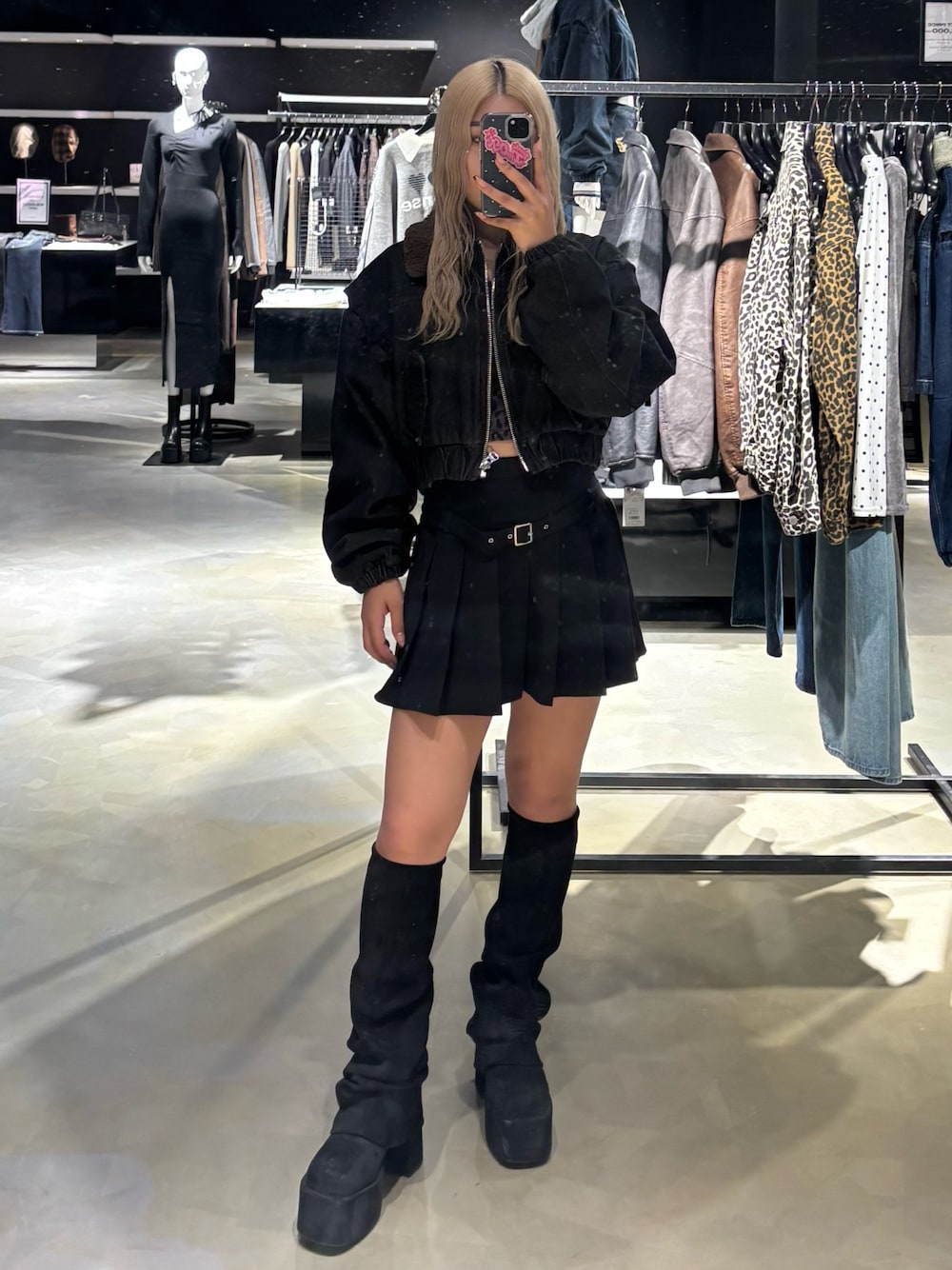 ブラック系のブルゾン、ブラック系のスカート、ブラック系のブーツを着用したレディースの秋コーディネートの1枚目の写真