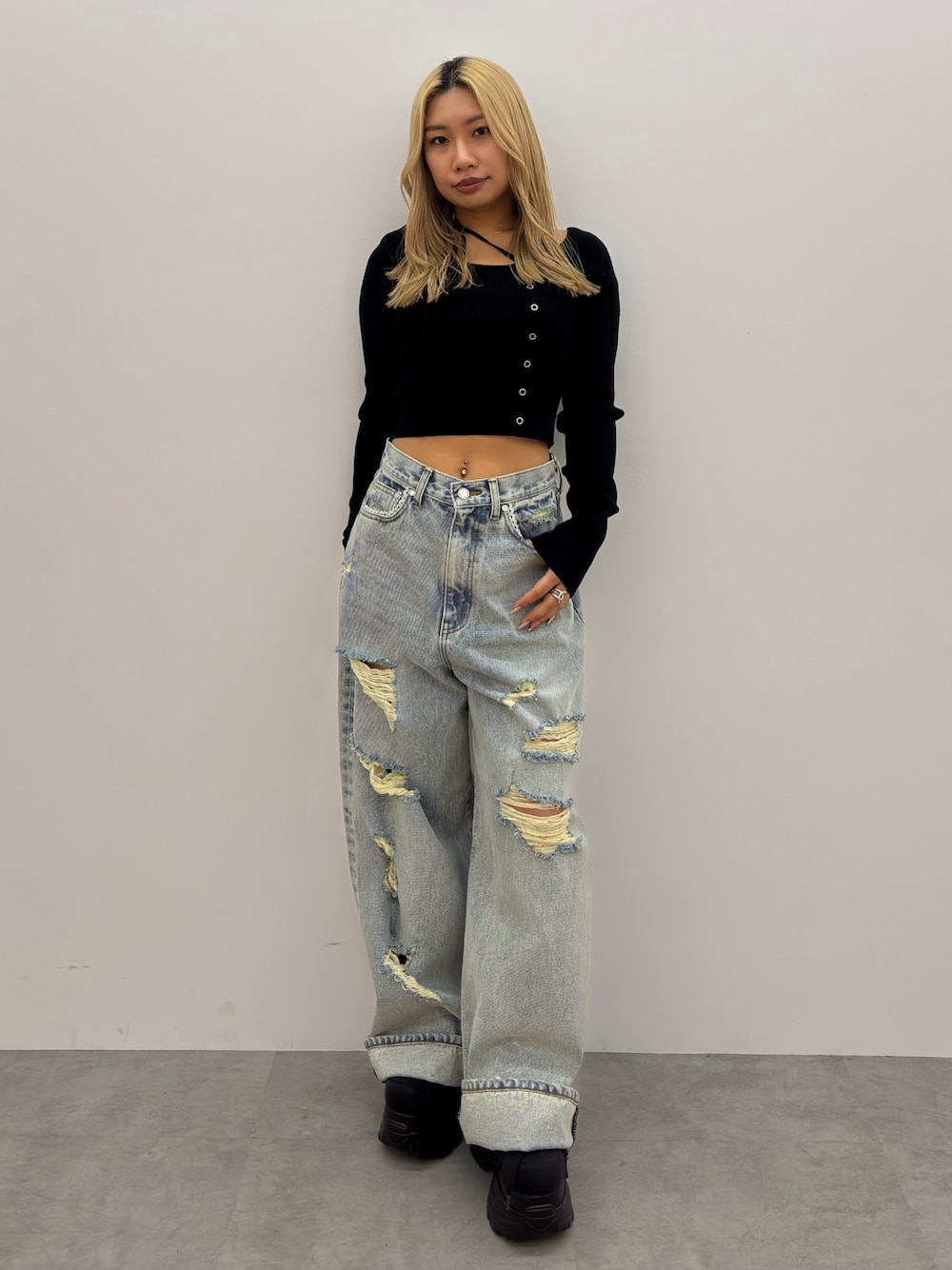 ブラック系のニット/セーター、ブルー系のデニムパンツ、ブラック系のスニーカーを着用したレディースの冬コーディネートの1枚目の写真