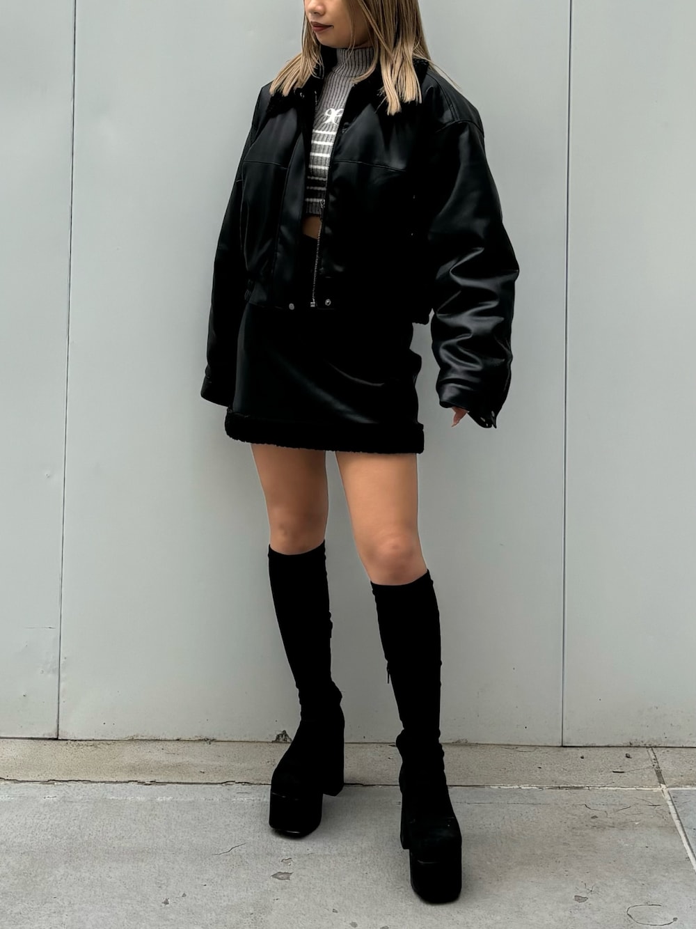 ブラック系のブルゾン、ブラック系のスカート、その他のブーツを着用したレディースの秋コーディネートの1枚目の写真