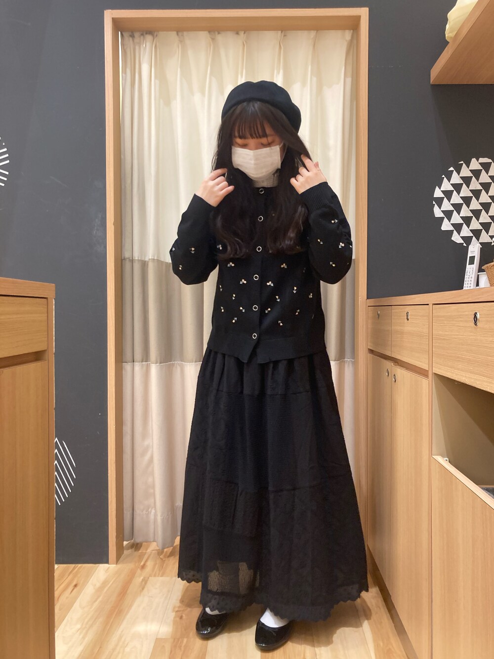 ブラック系のカーディガン/ボレロ、ブラック系のスカート、ブラック系のハンチング/ベレー帽を着用したレディースの春コーディネートの1枚目の写真
