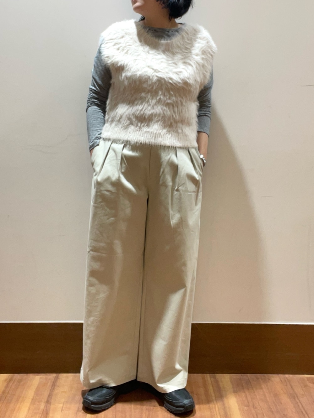 グレー系のベスト、ベージュ系のその他パンツ、ブラック系のTシャツ/カットソーを着用したレディースの冬コーディネートの1枚目の写真