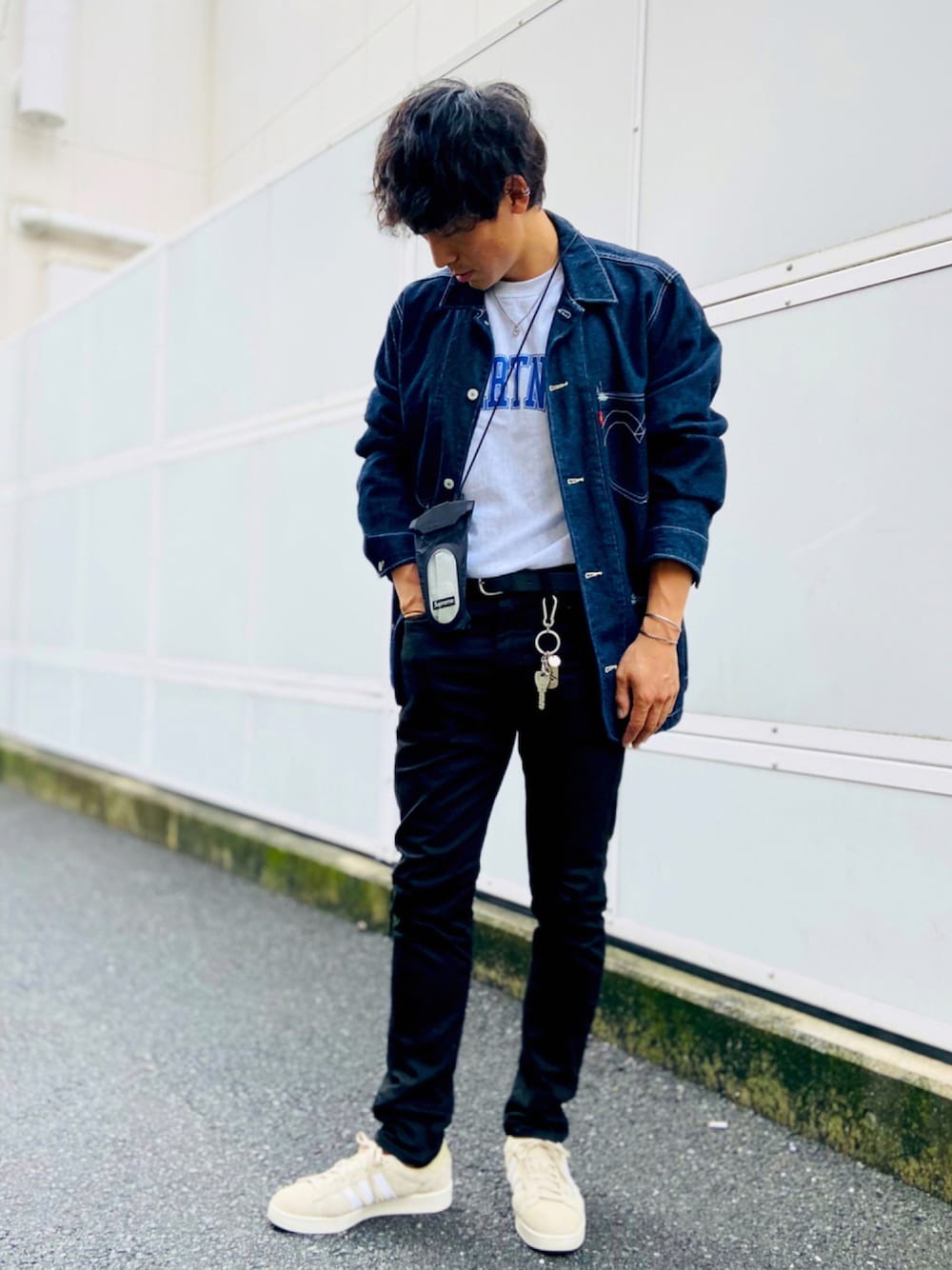 ブラック系のデニムパンツ、ベージュ系のスニーカー、ブラック系のショルダーバッグを着用したメンズの夏コーディネートの1枚目の写真
