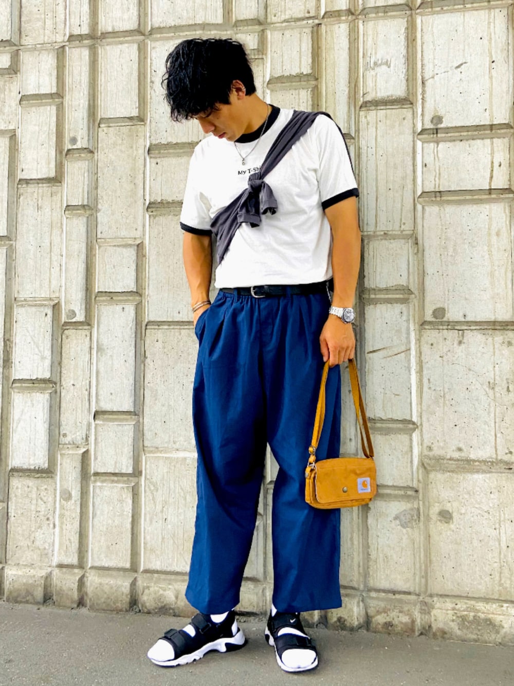 ブラウン系のボディバッグ/ウエストポーチ、ブルー系のスラックス、ブラック系のサンダルを着用したメンズの夏コーディネートの1枚目の写真