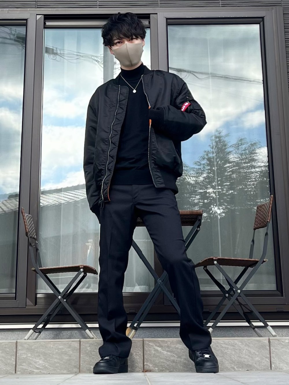 ブラック系のMA-1、ブルー系のニット/セーター、ブラック系のスラックスを着用したメンズの冬コーディネートの1枚目の写真