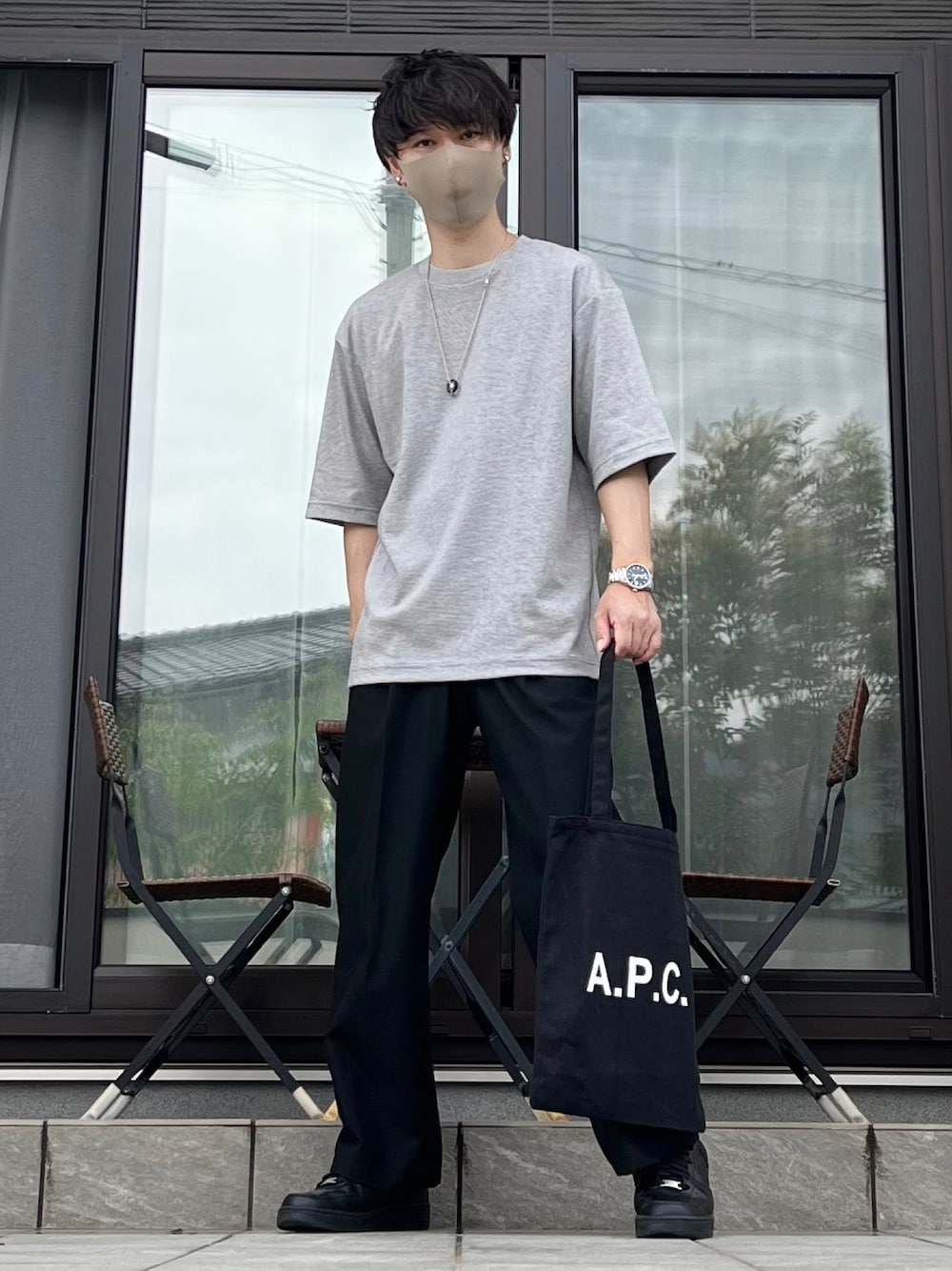 グレー系のTシャツ/カットソー、ブラック系のスラックス、ブラック系のスニーカーを着用したメンズの夏コーディネートの1枚目の写真