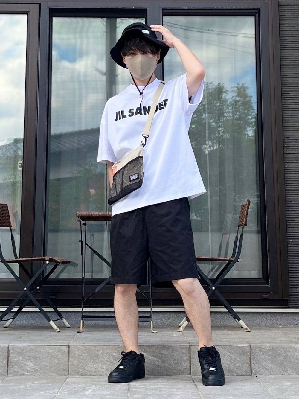 ベージュ系のショルダーバッグ、ホワイト系のTシャツ/カットソー、ブラック系のパンツを着用したメンズの夏コーディネートの1枚目の写真