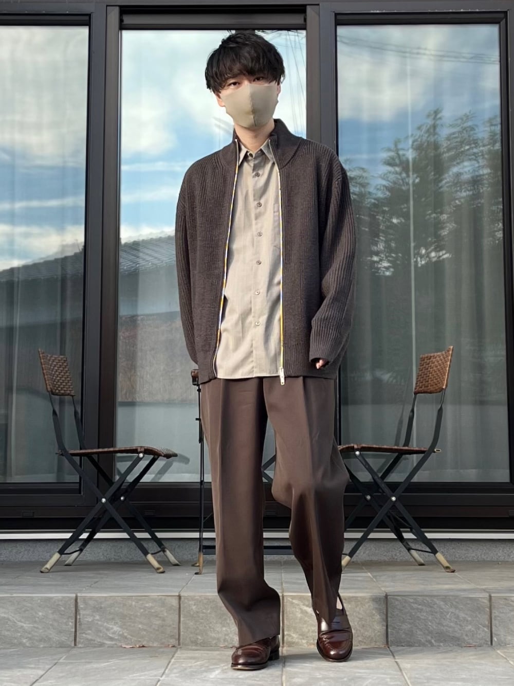 ブラウン系のスラックス、ベージュ系のシャツ/ブラウス、グレー系のニット/セーターを着用したメンズの秋コーディネートの1枚目の写真