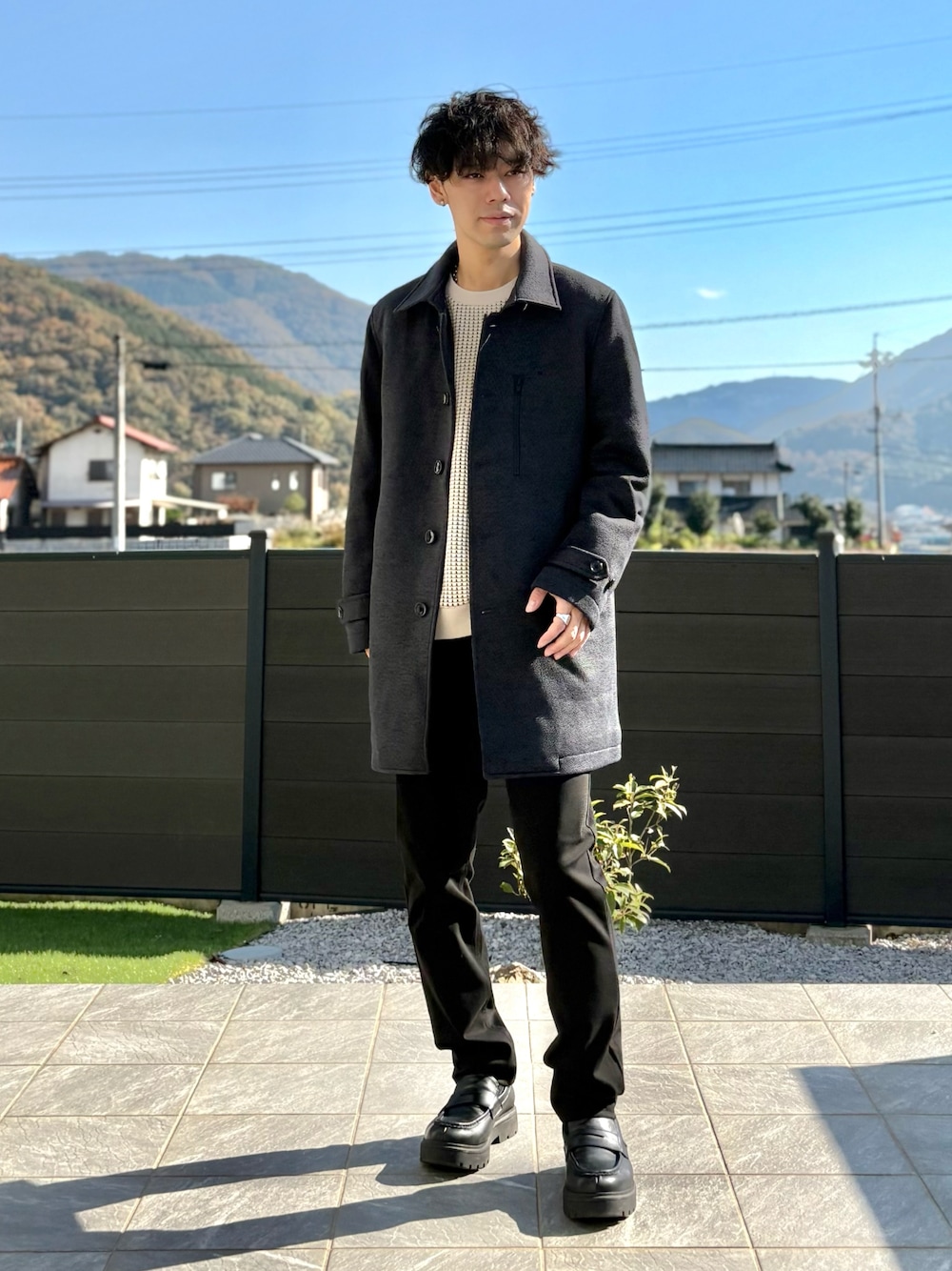 ブルー系のステンカラーコート、ベージュ系のスウェット、ブラック系のその他パンツを着用したメンズの秋コーディネートの1枚目の写真
