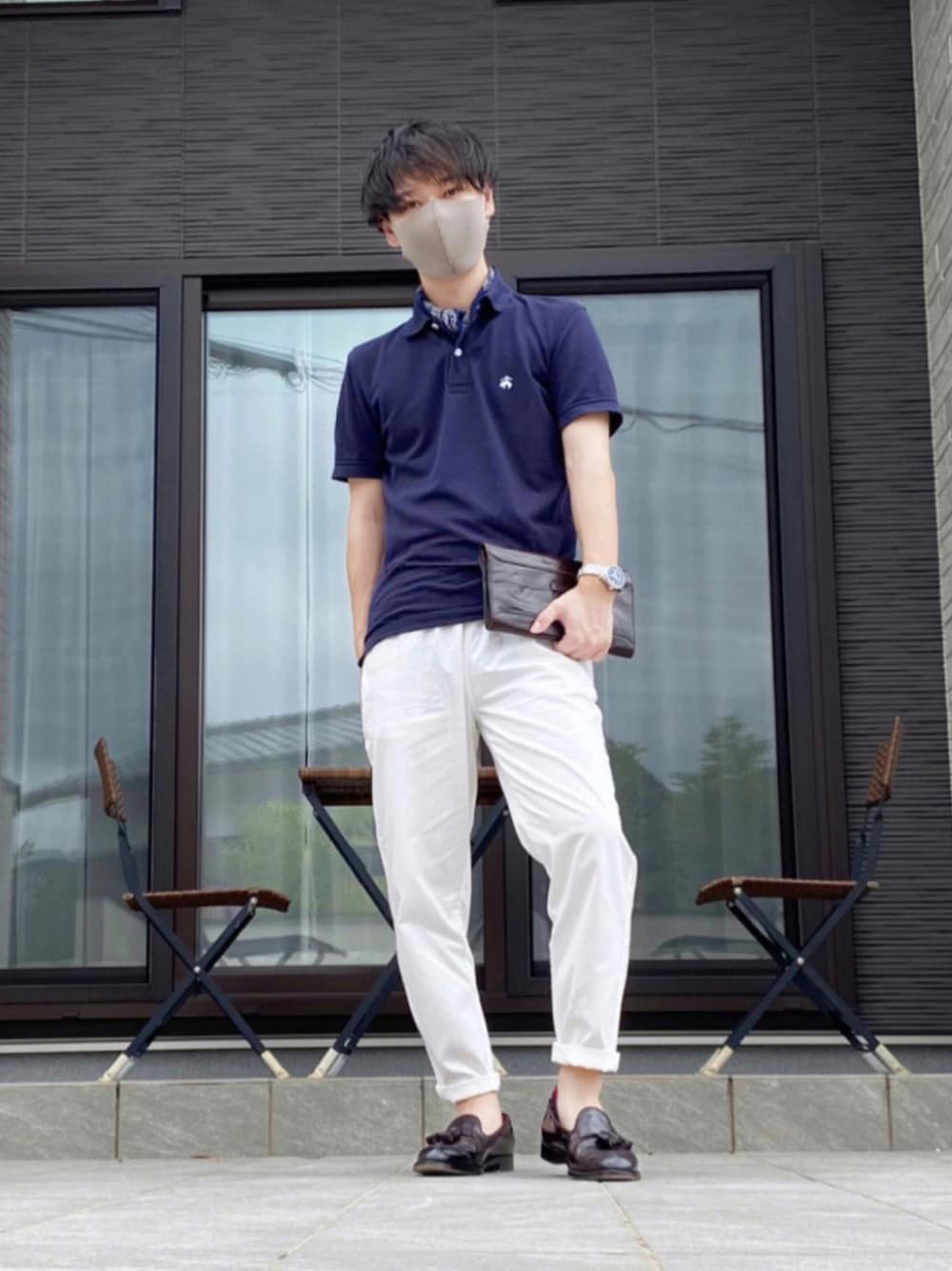 ホワイト系のチノパンツ、ブラウン系のローファー、ブラウン系のクラッチバッグを着用したメンズの夏コーディネートの1枚目の写真