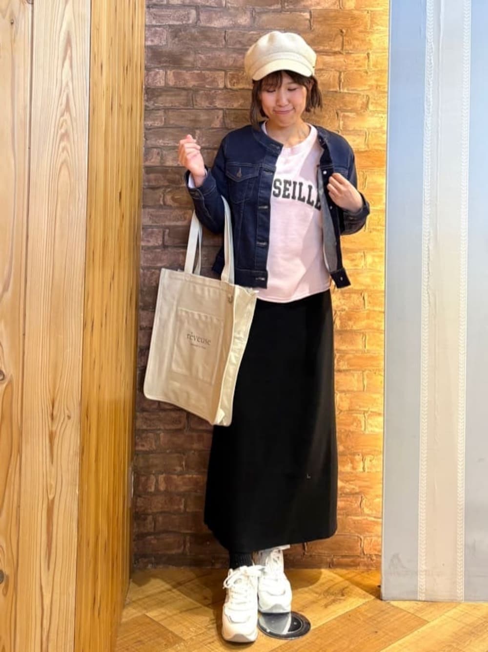 ブルー系のデニムジャケット、ブラック系のスカート、ピンク系のスウェットを着用したレディースの冬コーディネートの1枚目の写真