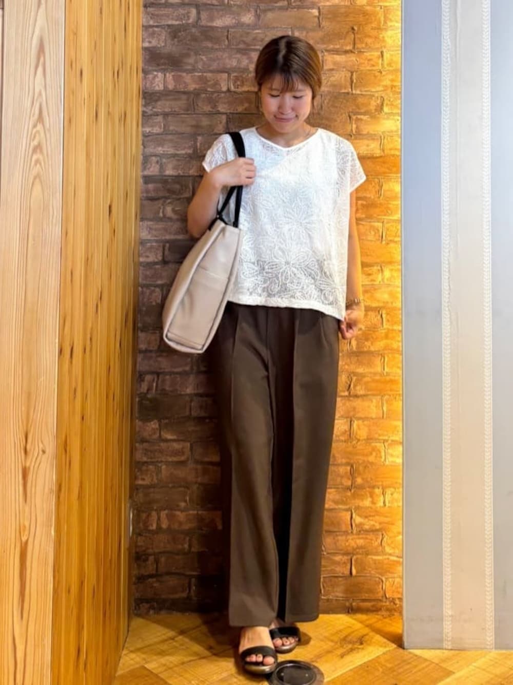 ホワイト系のその他トップス、ブラウン系のその他パンツ、ブラック系のサンダルを着用したレディースの夏コーディネートの1枚目の写真