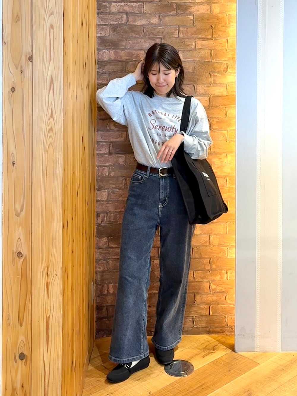 グレー系のTシャツ/カットソー、ブルー系のデニムパンツ、ブラック系のその他シューズを着用したレディースの秋コーディネートの1枚目の写真