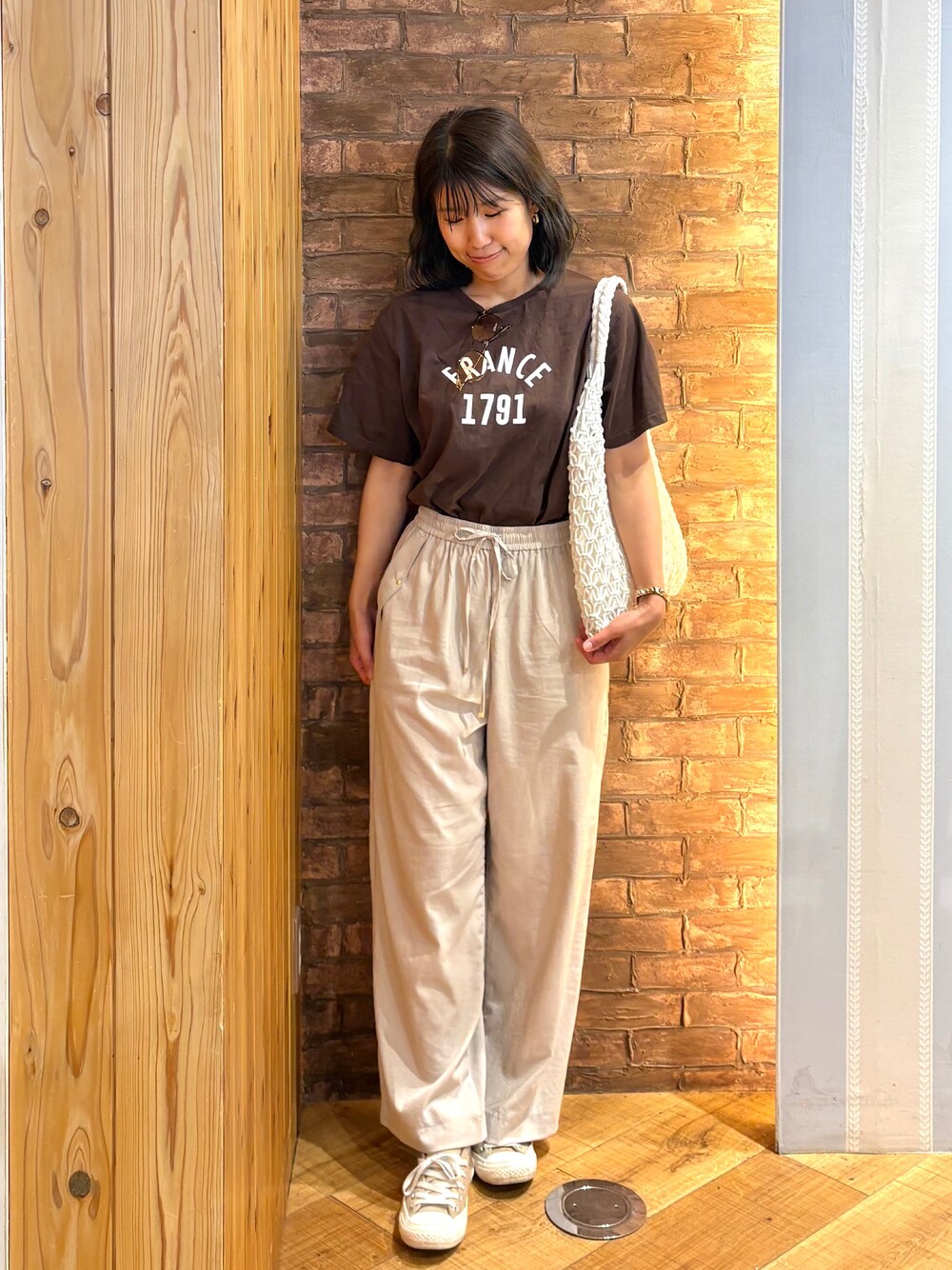 ブラウン系のTシャツ/カットソー、ベージュ系のその他パンツ、ホワイト系のトートバッグを着用したレディースの夏コーディネートの1枚目の写真