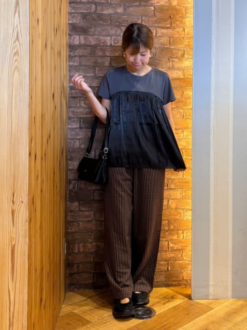 ブラック系のTシャツ/カットソー、ブラウン系のその他パンツ、ブラック系のスニーカーを着用したレディースの夏コーディネートの1枚目の写真