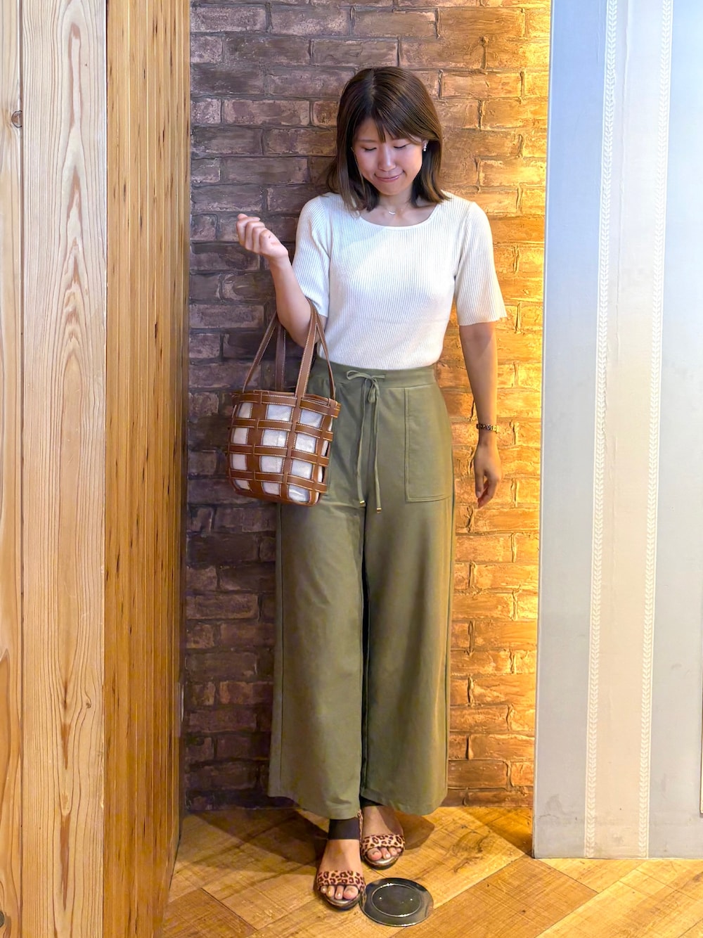 ホワイト系のニット/セーター、グリーン系のその他パンツ、ブラウン系のサンダルを着用したレディースの夏コーディネートの1枚目の写真