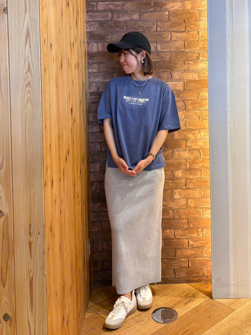 ブルー系のTシャツ/カットソー、グレー系のスカート、ホワイト系のスニーカーを着用したレディースの夏コーディネートの1枚目の写真