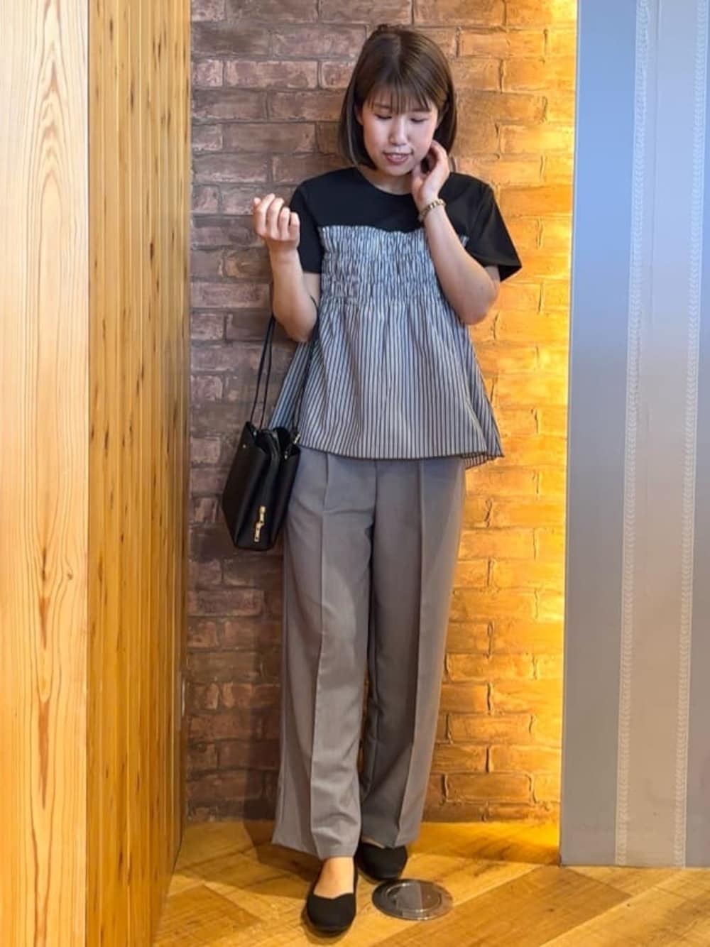 ブラック系のTシャツ/カットソー、グレー系のその他パンツ、ブラック系のパンプスを着用したレディースの春コーディネートの1枚目の写真