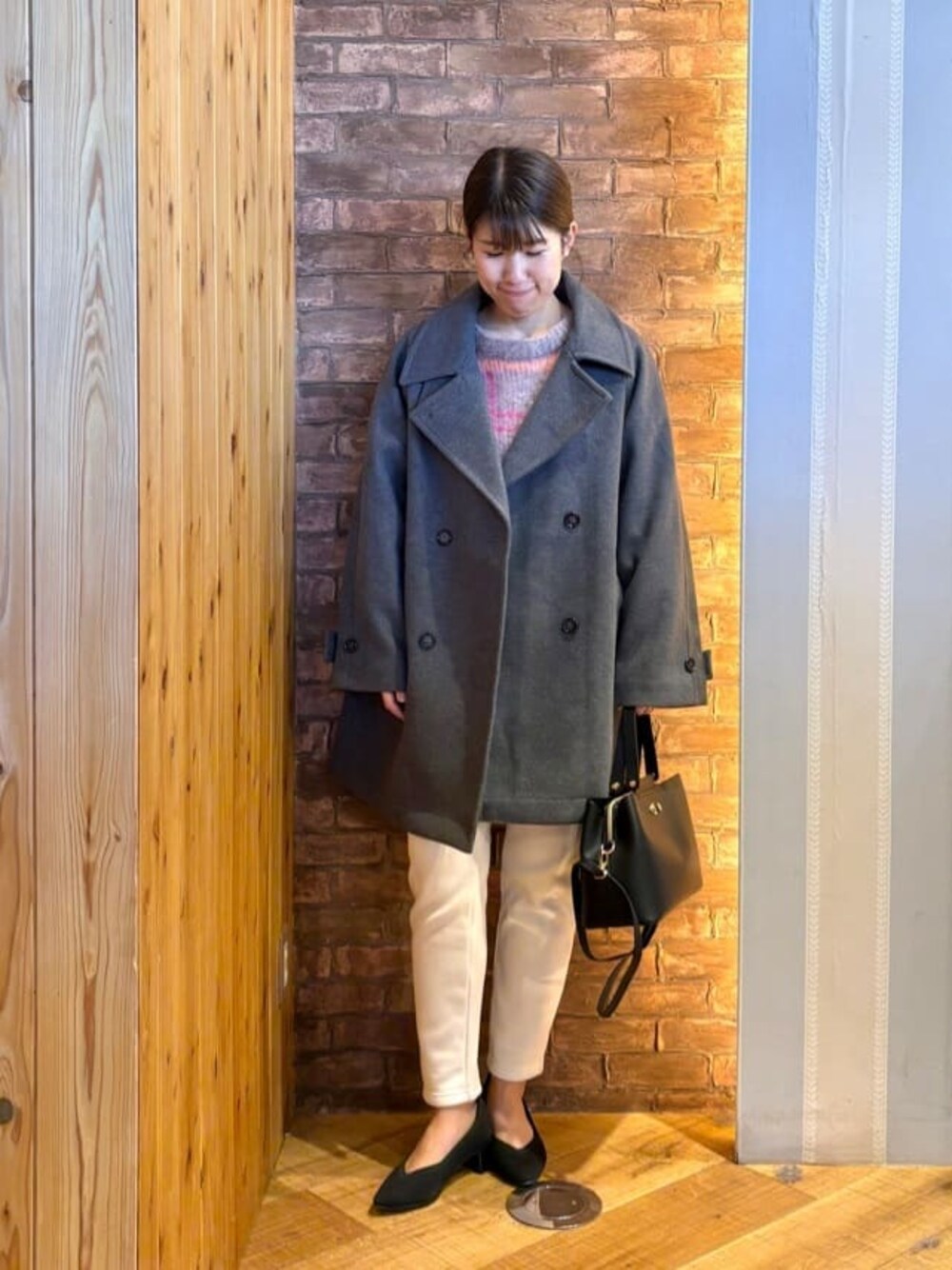 グレー系のチェスターコート、ピンク系のニット/セーター、ホワイト系のその他パンツを着用したレディースの冬コーディネートの1枚目の写真