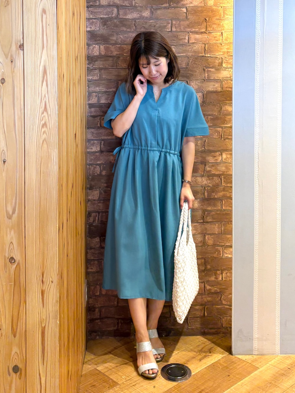 ブルー系のワンピース、シルバー系のサンダル、ホワイト系のトートバッグを着用したレディースの夏コーディネートの1枚目の写真