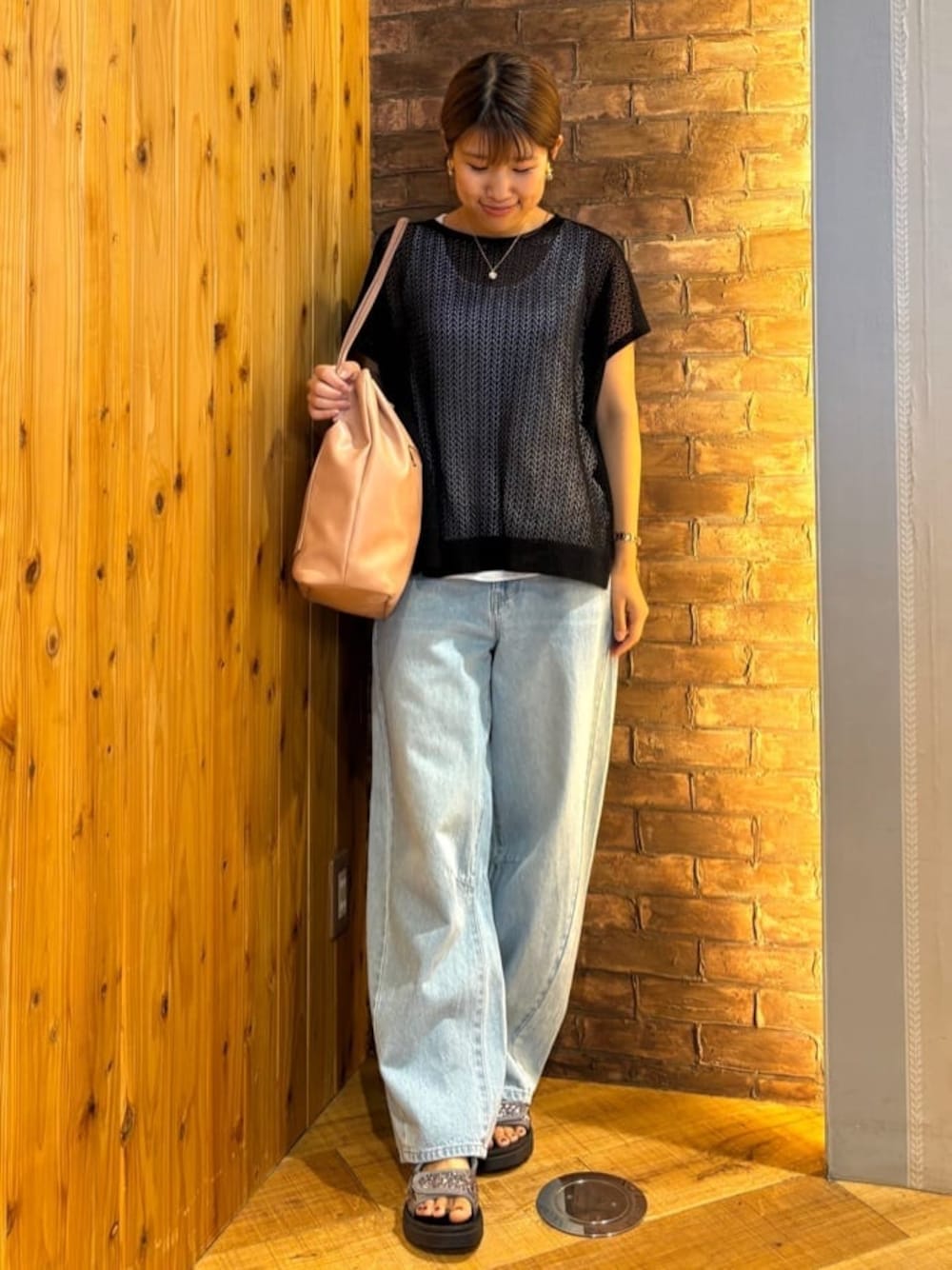 ブラック系のニット/セーター、ブルー系のデニムパンツ、シルバー系のサンダルを着用したレディースの夏コーディネートの1枚目の写真