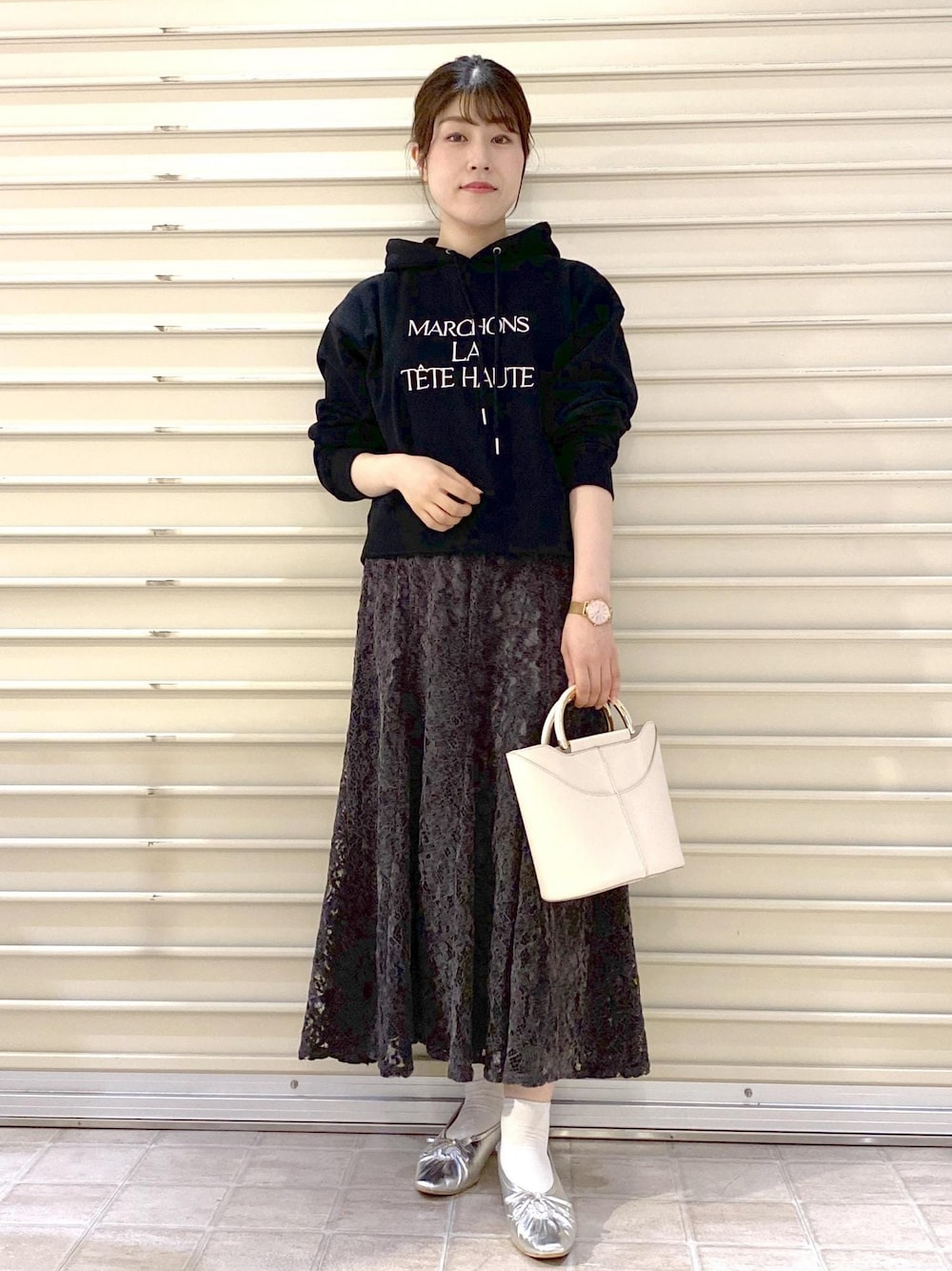 シルバー系のパンプス、ブラック系のパーカー、グレー系のスカートを着用したレディースの秋コーディネートの1枚目の写真