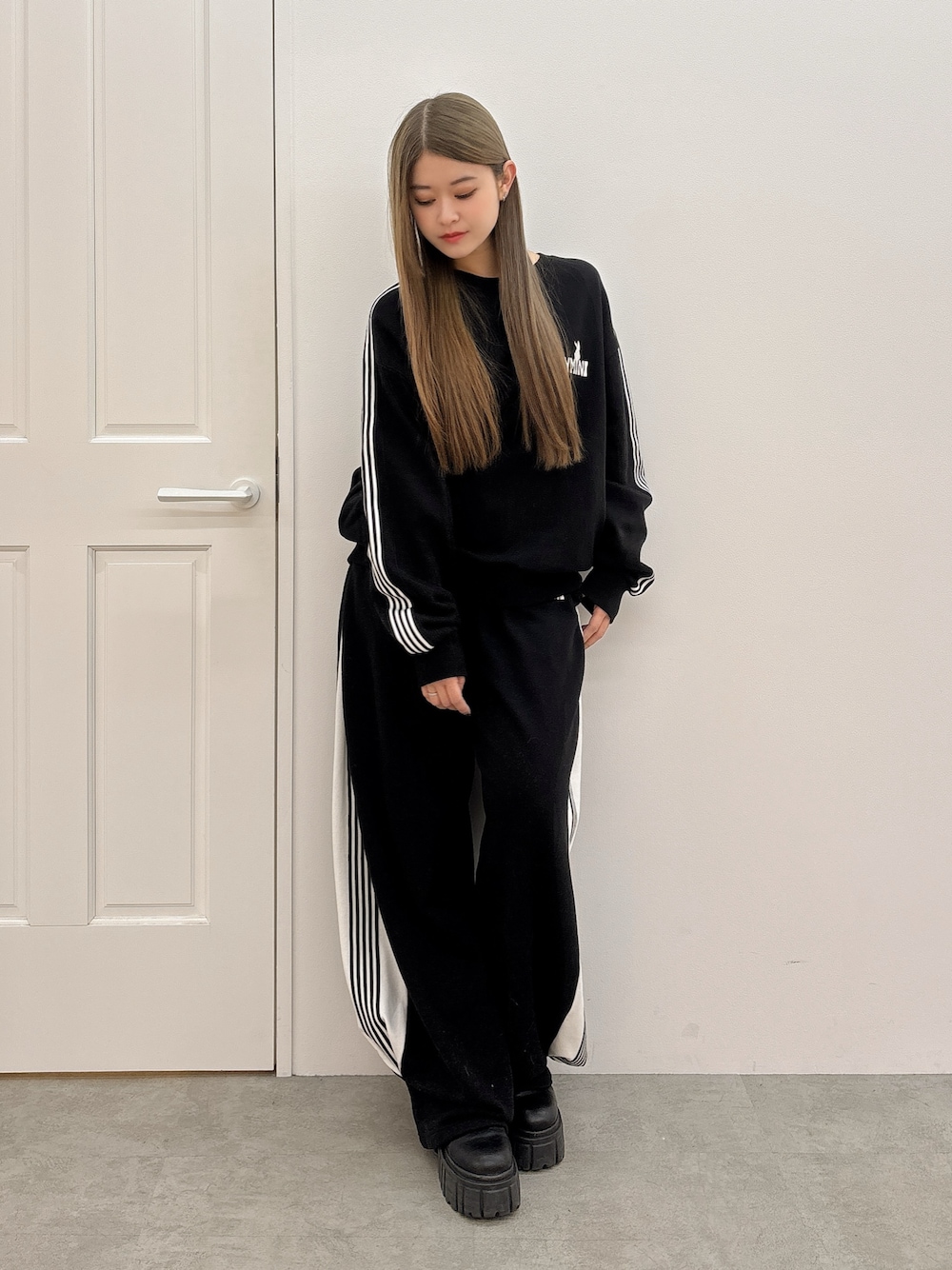 ブラック系のスウェットパンツ、ブラック系のスウェット、ブラック系のブーツを着用したレディースの冬コーディネートの1枚目の写真