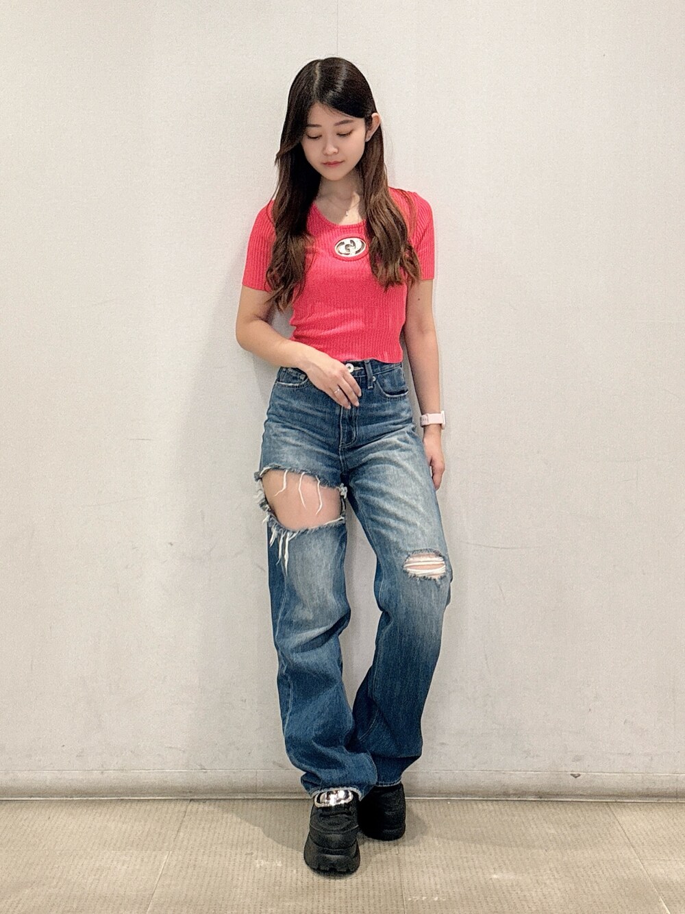 ピンク系のニット/セーター、ブルー系のデニムパンツ、ブラック系のスニーカーを着用したレディースの春コーディネートの1枚目の写真