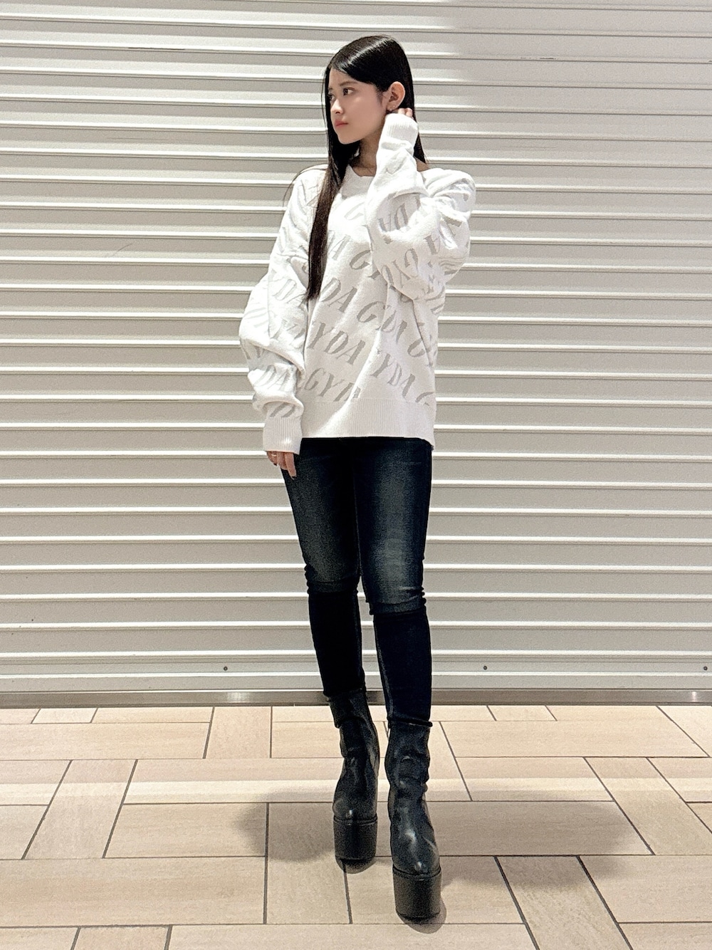 ホワイト系のニット/セーター、ブルー系のデニムパンツ、ブラック系のブーツを着用したレディースの秋コーディネートの1枚目の写真