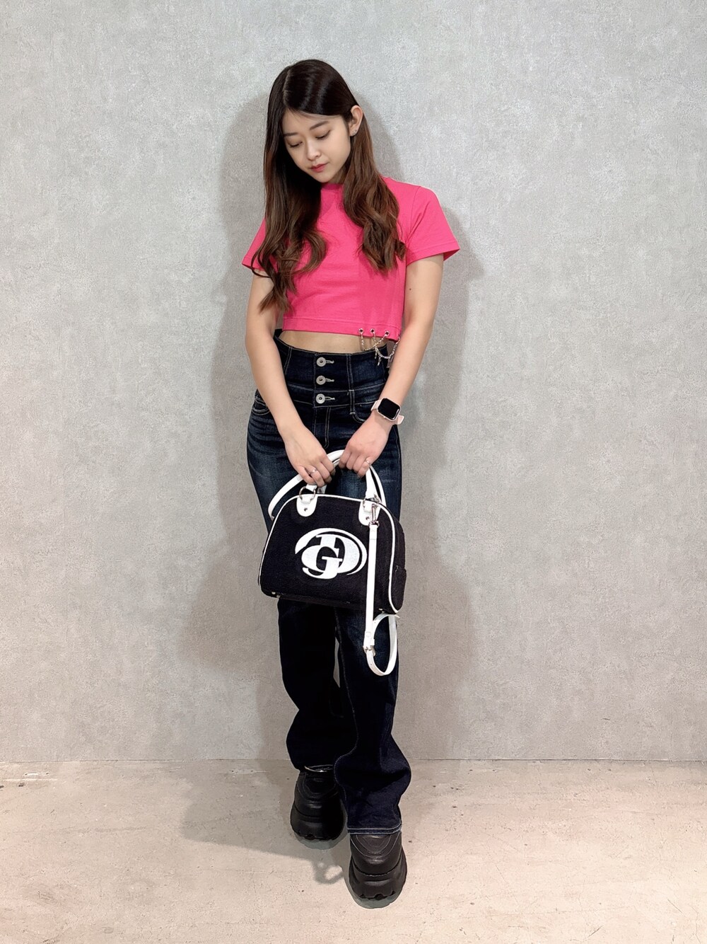ピンク系のTシャツ/カットソー、ブルー系のデニムパンツ、ブラック系のハンドバッグを着用したレディースの春コーディネートの1枚目の写真