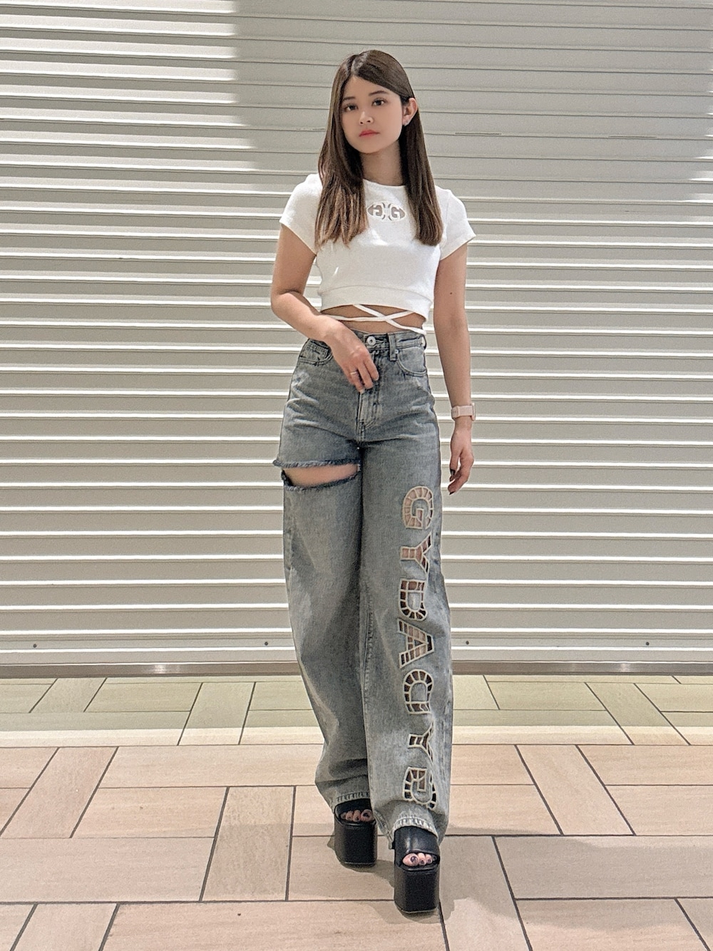 ホワイト系のTシャツ/カットソー、ブルー系のデニムパンツ、ブラック系のサンダルを着用したレディースの春コーディネートの1枚目の写真