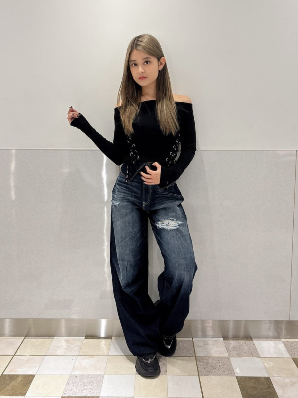ブルー系のデニムパンツ、ブラック系のスニーカー、ブラック系のTシャツ/カットソーを着用したレディースの秋コーディネートの1枚目の写真