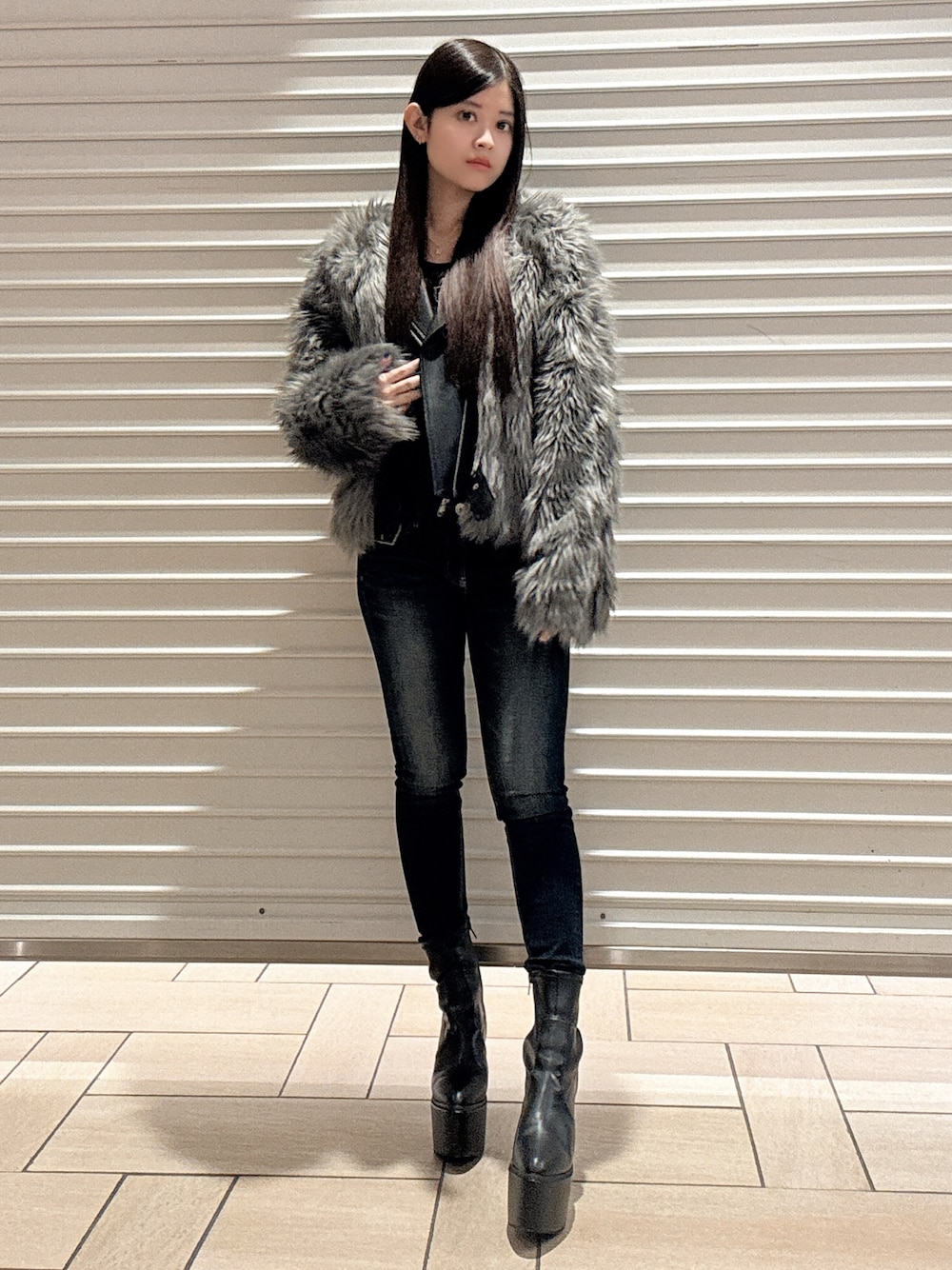 ブラック系のニット/セーター、グレー系のライダースジャケット、ブルー系のデニムパンツを着用したレディースの秋コーディネートの1枚目の写真