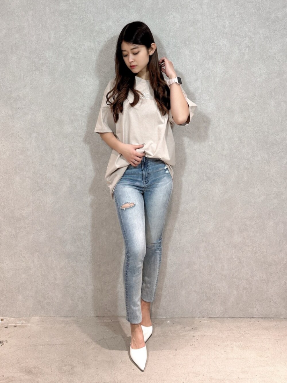 ベージュ系のTシャツ/カットソー、ブルー系のデニムパンツ、ホワイト系のパンプスを着用したレディースの春コーディネートの1枚目の写真