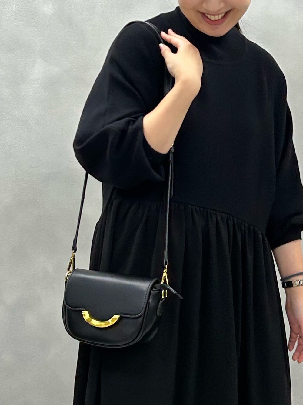 ブラック系のワンピース、ブラック系のショルダーバッグを着用したレディースの夏コーディネートの3枚目の写真