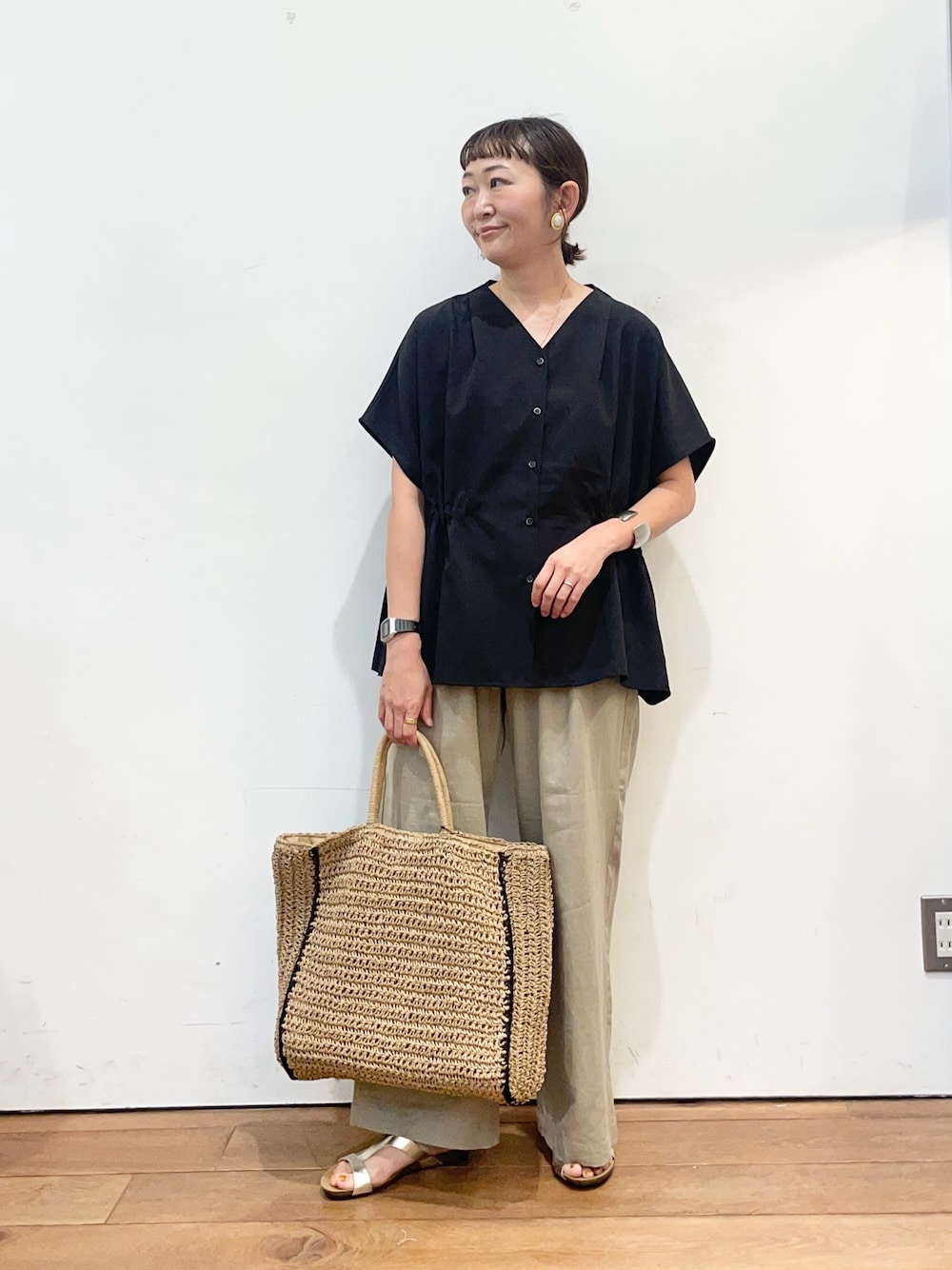 ブラック系のシャツ/ブラウス、ベージュ系のその他パンツ、ゴールド系のサンダルを着用したレディースの夏コーディネートの1枚目の写真