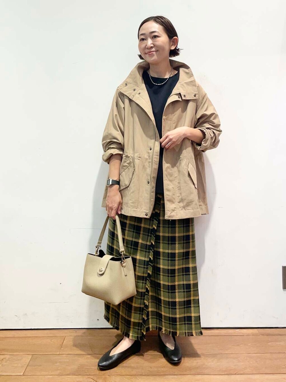 ブラック系のパンプス、ベージュ系のその他アウター、ベージュ系のショルダーバッグを着用したレディースの秋コーディネートの1枚目の写真