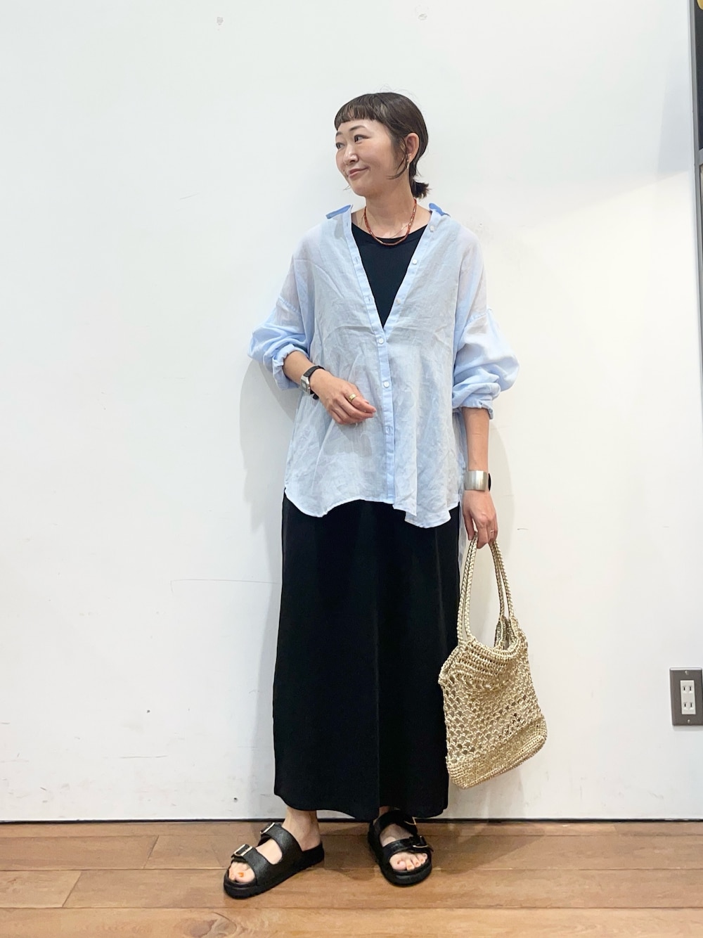 ブルー系のシャツ/ブラウス、ブラック系のワンピース、ゴールド系のトートバッグを着用したレディースの夏コーディネートの1枚目の写真