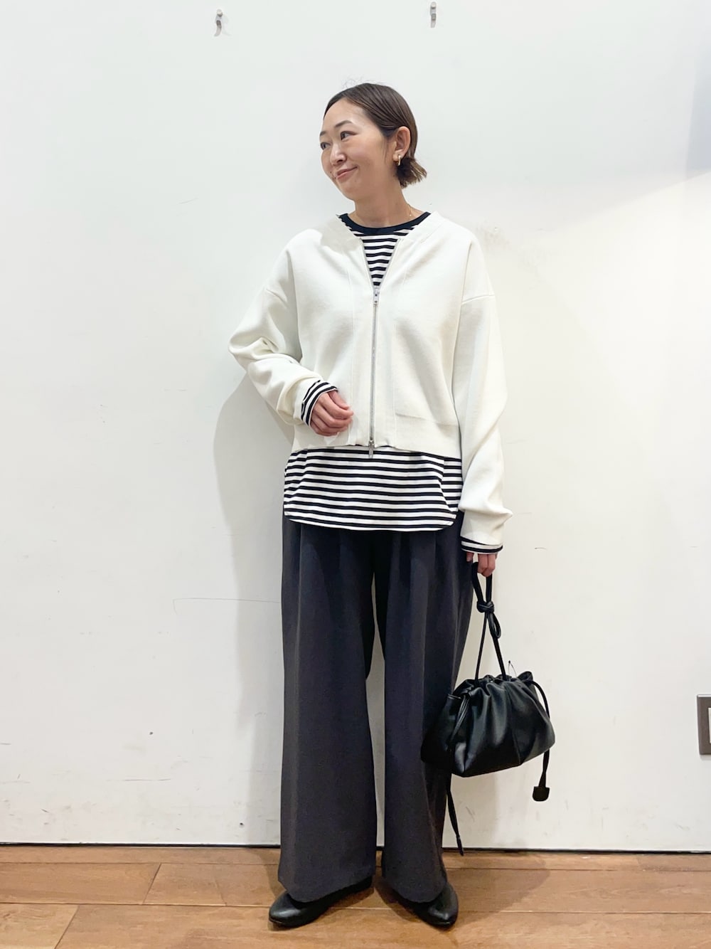 ホワイト系のカーディガン/ボレロ、ホワイト系のTシャツ/カットソー、グレー系のその他パンツを着用したレディースの春コーディネートの1枚目の写真