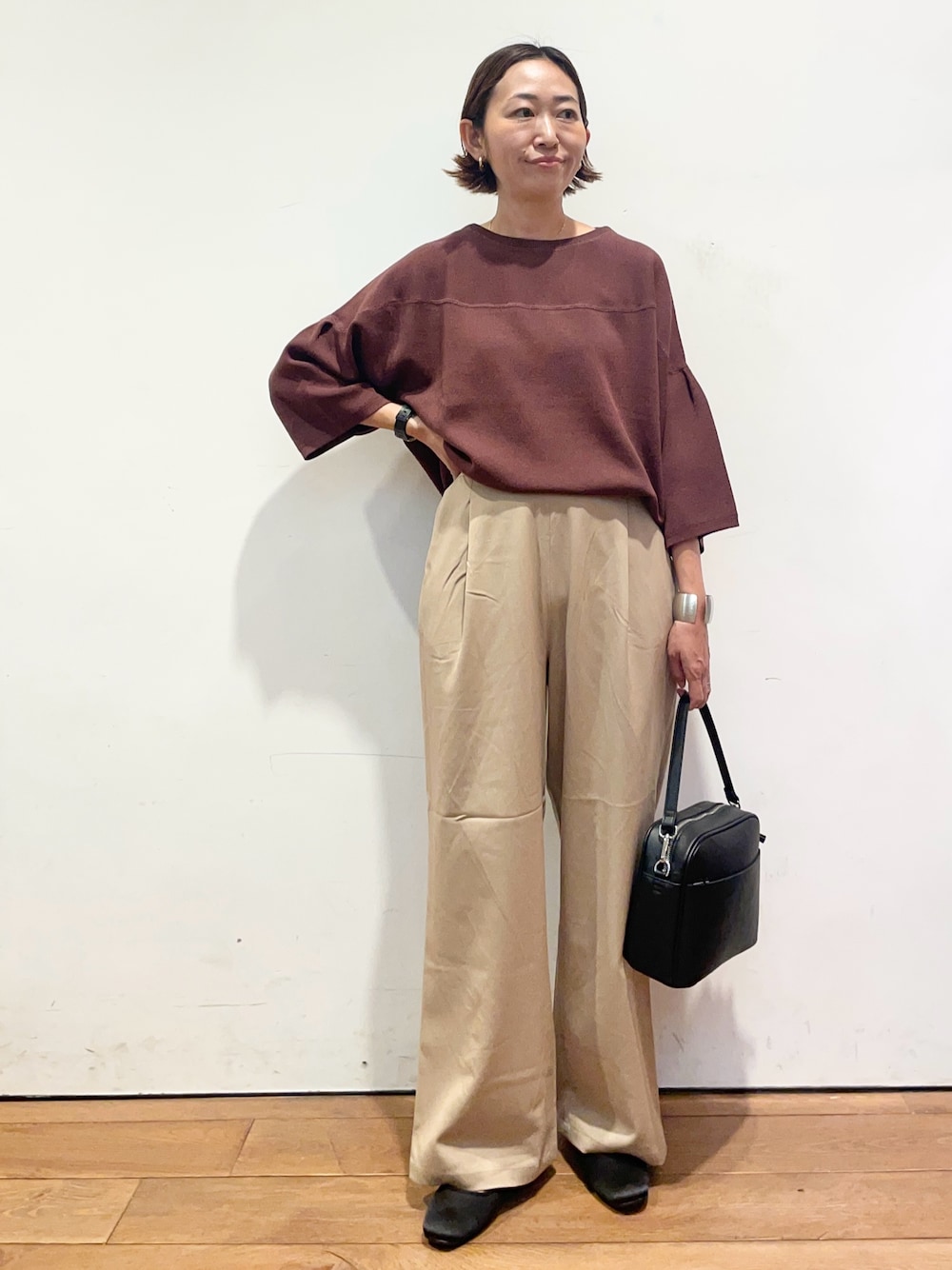 ベージュ系のその他パンツ、ブラウン系のニット/セーター、ブラック系のショルダーバッグを着用したレディースの秋コーディネートの1枚目の写真